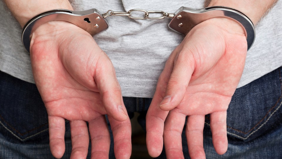 мужские руки в наручниках