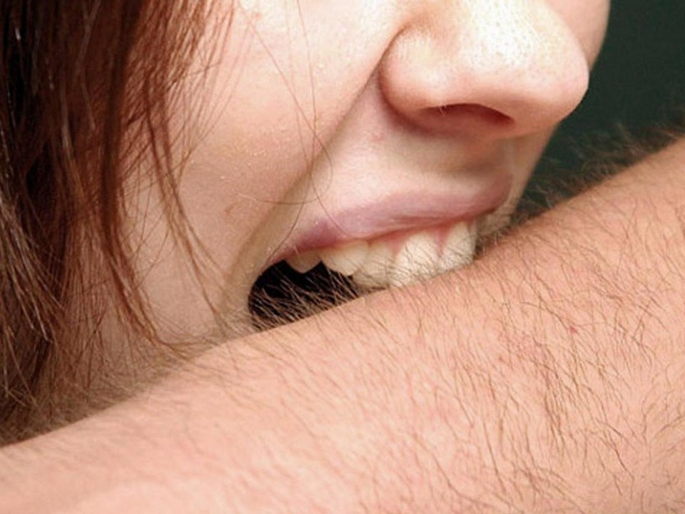 Женщина кусает за руку