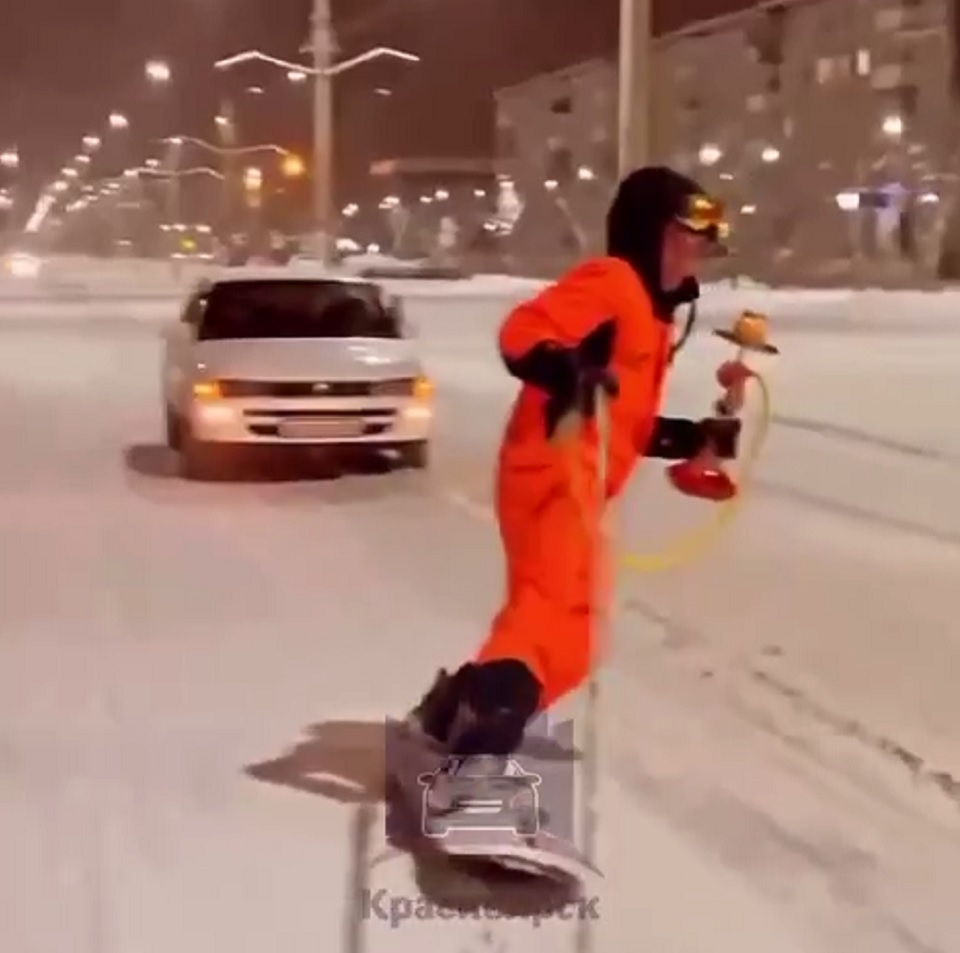 парень едет на сноуборде с кальяном по дороге