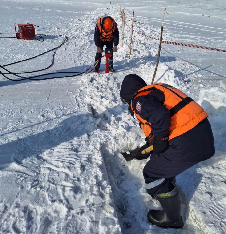 Спасатели делают траншею во льду