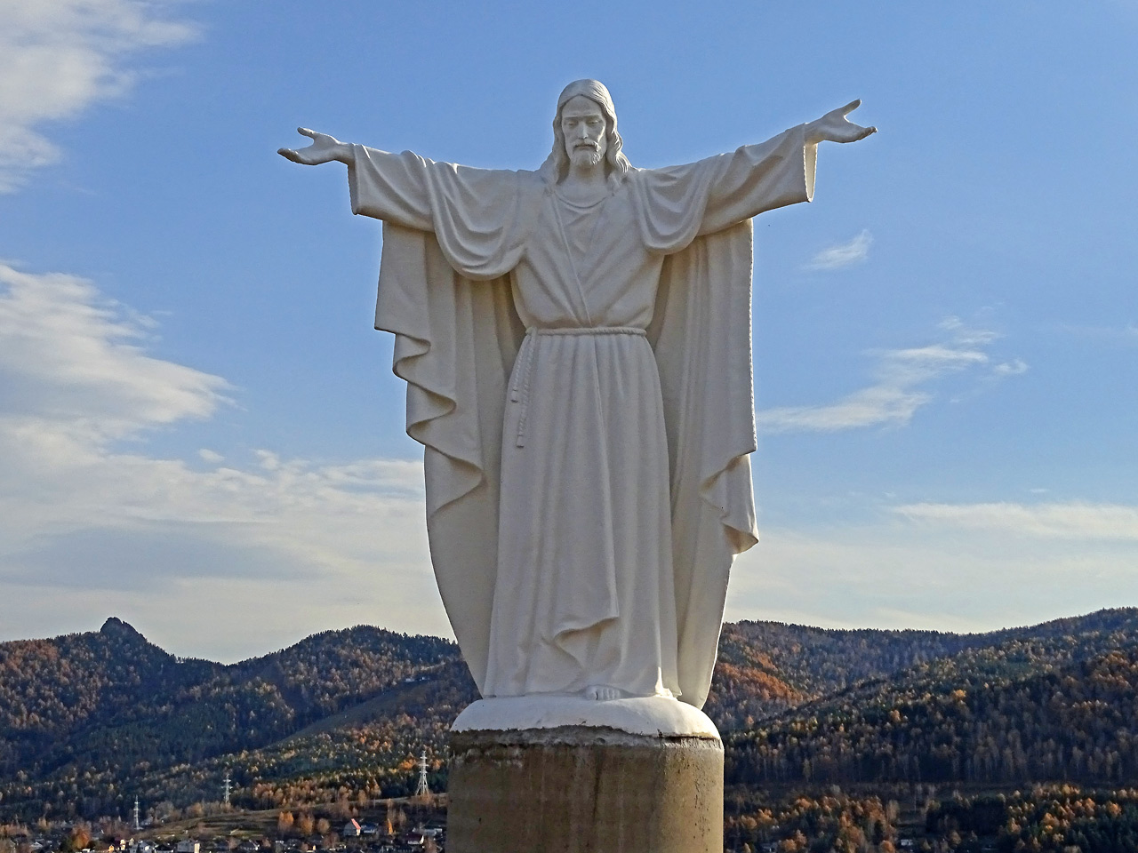 Статуя Христа на фоне отрогов Саянских гор и Такмака