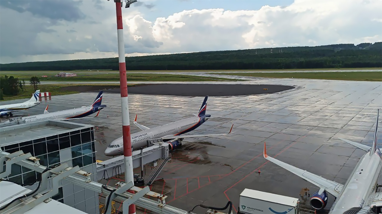 Самолеты на перроне аэропорта Красноярск - вид из терминала