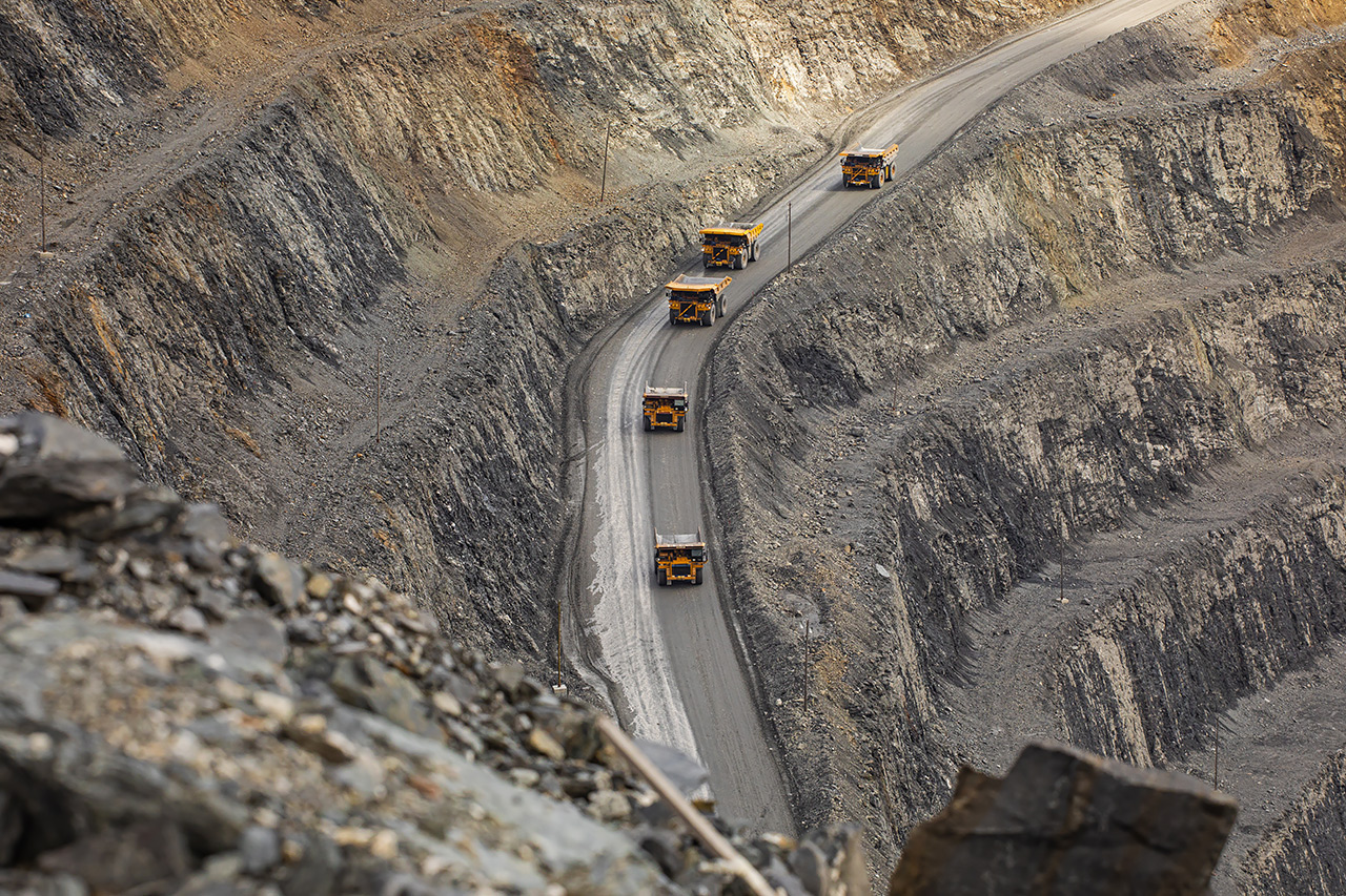 Вереница карьерных самосвалов Полюса вид сверху