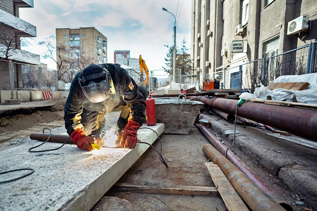 Ремонт теплотрассы в Красноярске - сварщик сваривает трубы