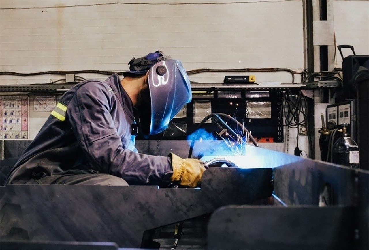Работа на предприятии - сварщик сваривает